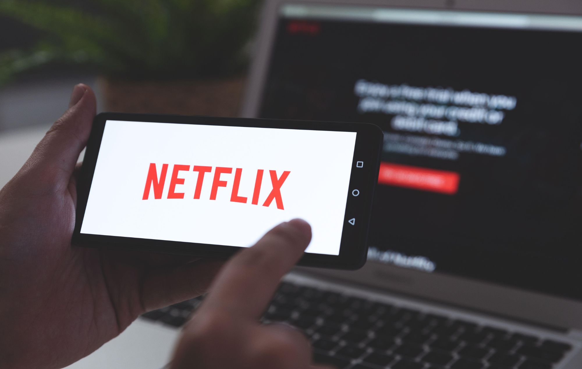 Stock image of a Man with Netflix logo on screen.