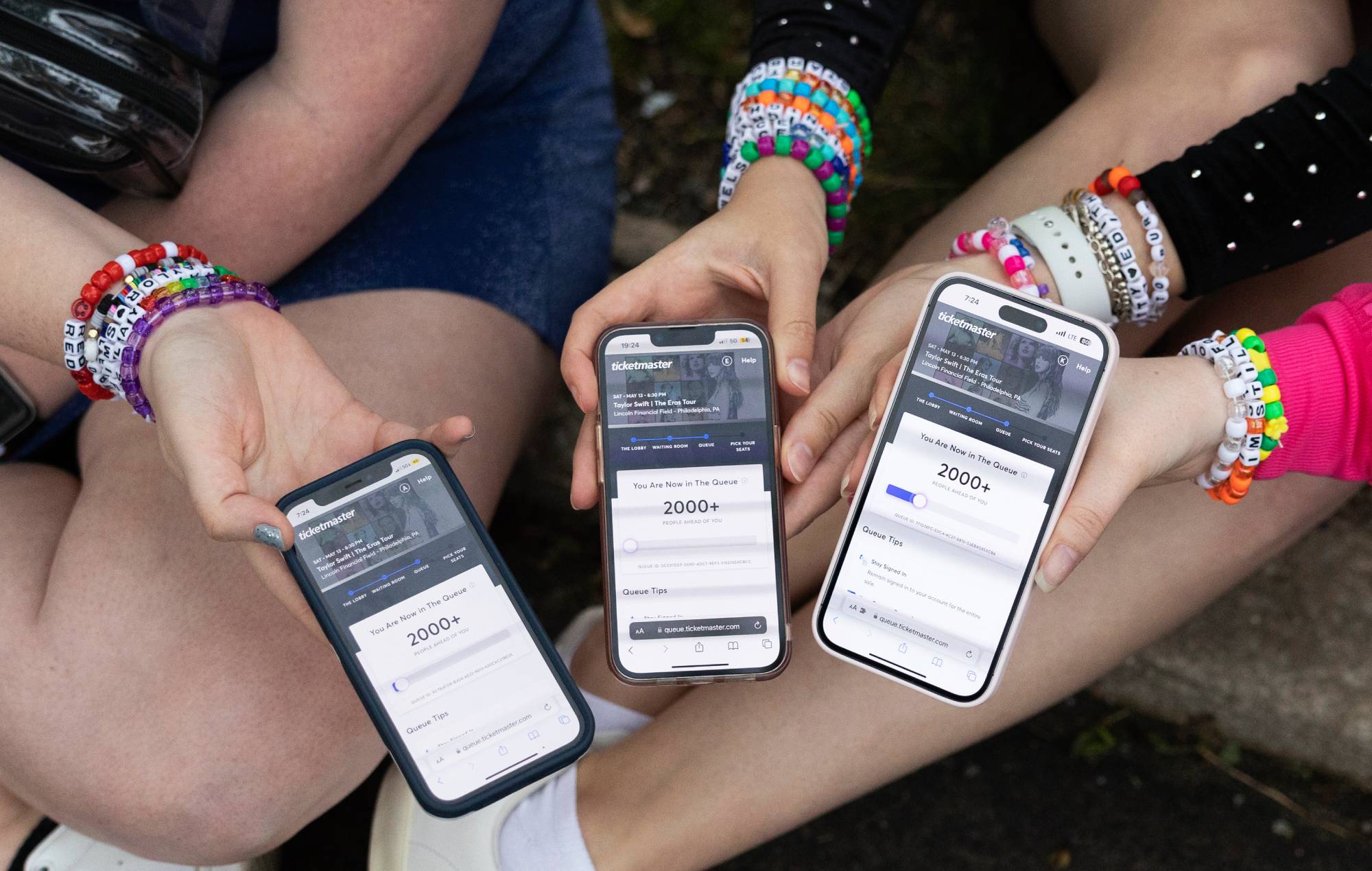 Anna Mason, Emily Lind, and Kristen Robinson show their Ticketmaster queue, which displays over 2000+ people ahead of them, from the parking lot outside of the Taylor Swift concert at Lincoln Financial Field in Philadelphia, Pennsylvania on May 13, 2023. Credit: Rachel Wisniewski/GETTY