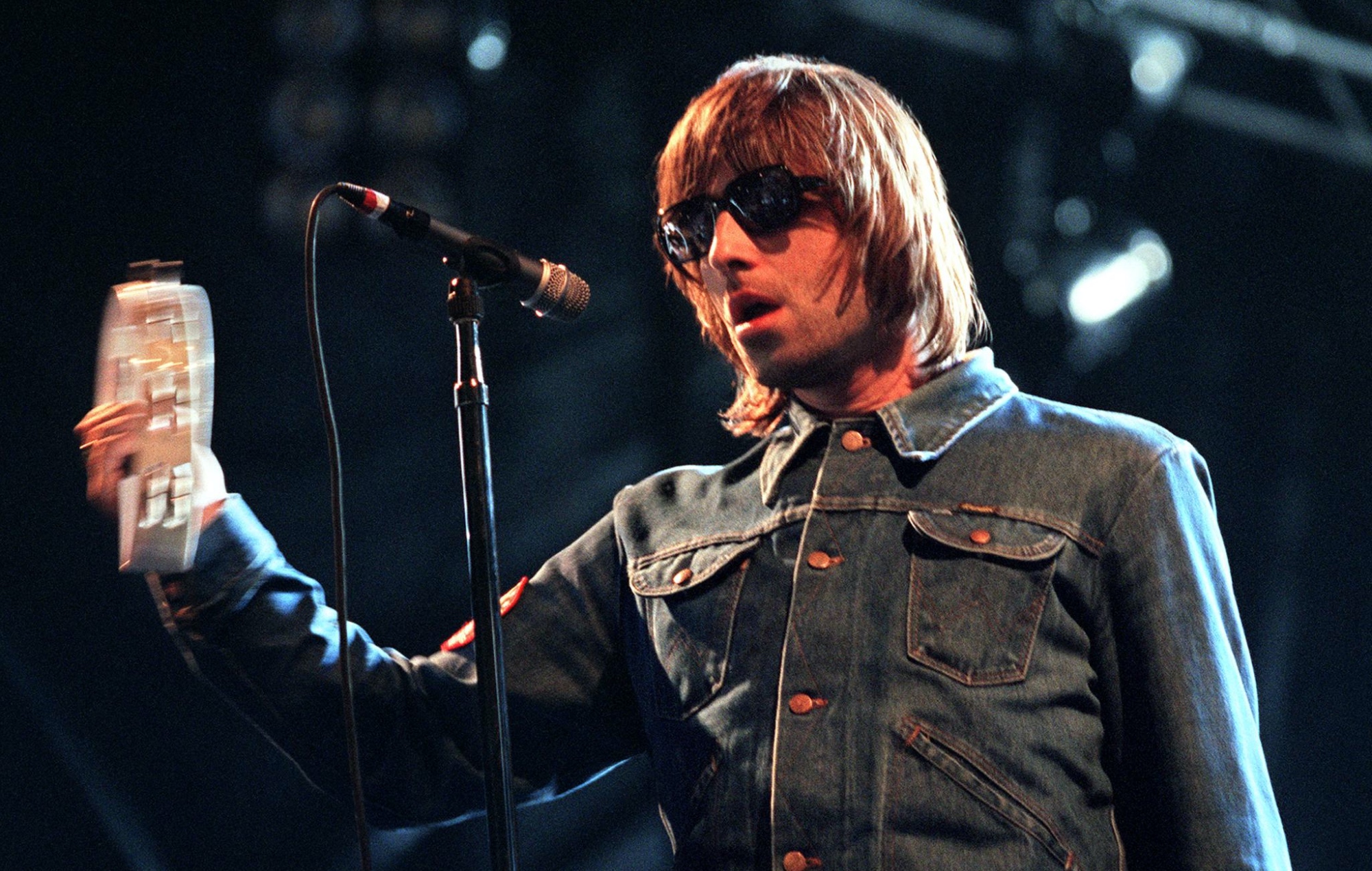 Liam Gallagher performing live on stage with Oasis in 2000